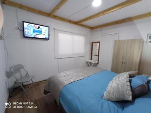 a bedroom with a bed and a tv on the wall at Loft Tongoy Peninsula sin estacionamiento in Coquimbo