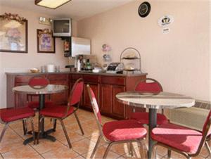 una cocina con 2 mesas y sillas y una barra en Super 8 by Wyndham Oklahoma Fairgrounds, en Oklahoma City