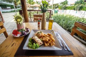 een bord eten op een houten tafel bij LAGUNA BEACH BY NT in Porto De Galinhas