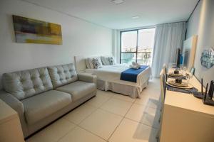 een woonkamer met een bed en een bank bij LAGUNA BEACH BY NT in Porto De Galinhas