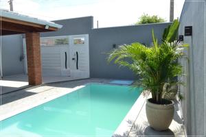 a potted plant sitting next to a swimming pool at Recanto da Valtana com piscina in Olímpia