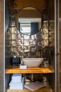 een badkamer met een wastafel en een spiegel bij Eigenheimer B&B in Simpelveld