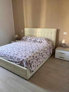 a large bed in a bedroom with two night stands at La Piazzetta Anzio in Anzio