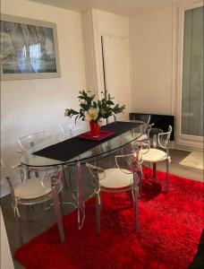 un tavolo di vetro e sedie con un tappeto rosso di Appartement Veules roses , la cressonnière: « Veules & Victor «  a Veules-les-Roses