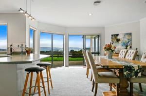 a kitchen and dining room with a table and chairs at Rotorua Lake View Villa in Hamurana