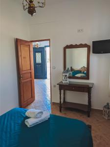 a bedroom with a blue bed and a mirror at Chrysiis House 1 in Analipsi