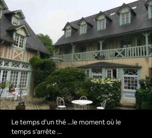 una grande casa con una donna seduta davanti di Appartement Veules roses , la cressonnière: « Veules & Victor «  a Veules-les-Roses