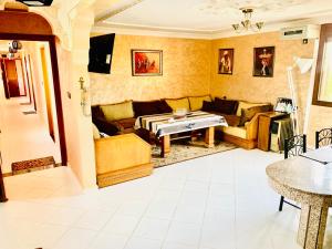 - un salon avec un canapé et une table dans l'établissement Gite Karima, à Madagh