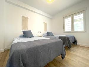 duas camas num quarto com duas janelas em Precioso apartamento recién reformado em Cambrils
