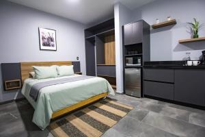 ein Schlafzimmer mit einem großen Bett und eine Küche in der Unterkunft Nidah Condominios in Durango