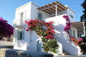 a white building with flowers in front of it at ARK Tinos in Agios Ioannis