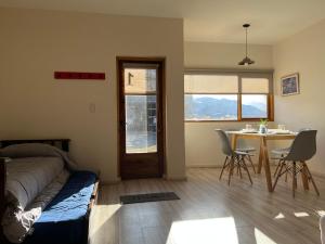a bedroom with a bed and a table and chairs at Chaltén Mountain Lofts 1 in El Chalten