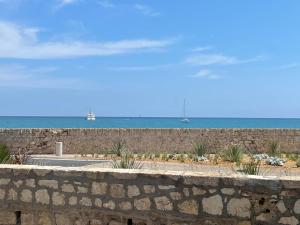 a stone wall with the ocean in the background at Appartement La Tourraque côté mer in Antibes