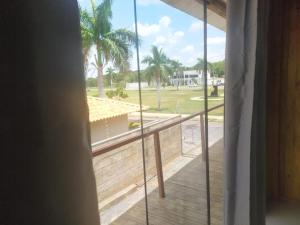 a room with a balcony with a view of a yard at Formosa Suites in Bonito
