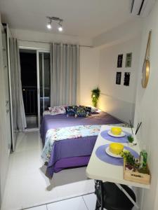 a bedroom with a bed and a table with plates on it at Lindo loft apartamento studio em Santana, perto do Expo Center Norte, Anhembi, Sambodromo, Campo de Marte, Zona Norte in Sao Paulo