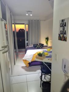 聖保羅的住宿－Lindo loft apartamento studio em Santana, perto do Expo Center Norte, Anhembi, Sambodromo, Campo de Marte, Zona Norte，一间卧室配有一张床、一张桌子和一张桌子