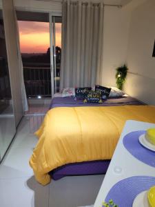1 dormitorio con cama amarilla y balcón en Lindo loft apartamento studio em Santana, perto do Expo Center Norte, Anhembi, Sambodromo, Campo de Marte, Zona Norte en São Paulo