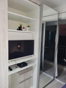 a living room with a large television and a window at Lindo loft apartamento studio em Santana, perto do Expo Center Norte, Anhembi, Sambodromo, Campo de Marte, Zona Norte in Sao Paulo