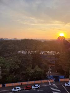 un coucher de soleil sur un parking avec des voitures garées dans l'établissement Lindo loft apartamento studio em Santana, perto do Expo Center Norte, Anhembi, Sambodromo, Campo de Marte, Zona Norte, à São Paulo