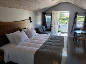 una camera con un grande letto e un soggiorno di Adventure the Bruce Inn - Recently Renovated With Outdoor Hot Tub a Tobermory