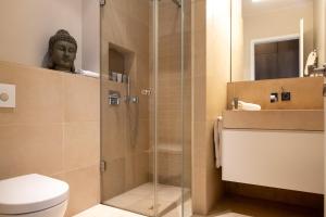 ein Badezimmer mit Dusche mit einer Frau im Spiegel in der Unterkunft The Wellem Residences in Düsseldorf