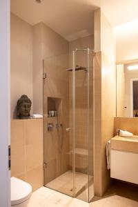 a shower with a glass door in a bathroom at The Wellem Residences in Düsseldorf