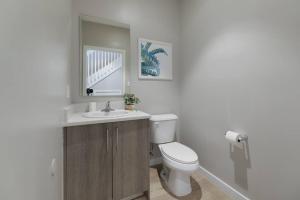 a bathroom with a toilet and a sink and a mirror at Fantastic Townhouse 15minutes from the Beach in Miami