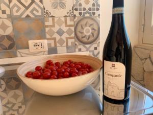 una bottiglia di vino accanto a un vasetto d'uva di Holiday House Villa AleGiù Marzamemi a Reitani