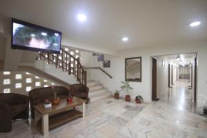 a living room with a tv and a staircase at Teju Hotels in Slănic