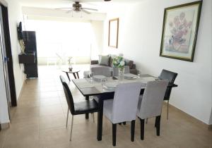 a dining table and chairs in a living room at Ecusuites Salinas Resort 7F Departamento Piscina in Salinas