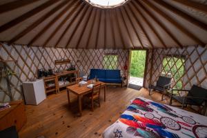 a room with a bed and a table in a yurt at La Lumineuse des yourtes du petit ruisseau in Mandeville