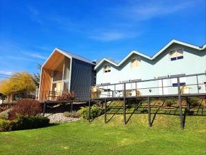 a home with a large deck and a house at Apart Hotel Jardín in El Calafate