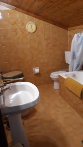 La salle de bains est pourvue d'un lavabo, de toilettes et d'une horloge. dans l'établissement Casa per vacanze degli gnomi, à Challancin 56 autres photos