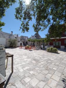 a patio with tables and chairs in a courtyard at Masseria Catucci Agriturismo in Alberobello