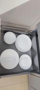 vier weiße Platten auf einem Regal in einem Ofen in der Unterkunft Cosmopolitan Apartament z bezpłatnym, prywatnym parkingiem w hali garażowej in Toruń