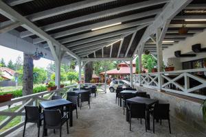 a restaurant with tables and chairs on a patio at Teju Hotels in Slănic