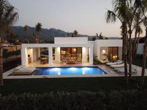 uma casa com uma piscina em frente em TAF Beach Villas with Tesla em Tigaki