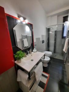 a bathroom with a sink and a toilet and a mirror at Campi Elisi in Syracuse