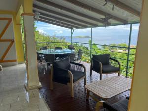 a patio with a table and chairs and a view of the ocean at Grand Kaz'Amour - 3 étoiles in Bouillante