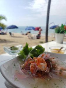a plate of food with shrimp on the beach at Ecusuites Playa Privada Piscina Jacuzzi 7B- a 10 min Salinas in Salinas