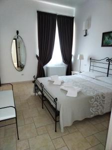 - une chambre avec un grand lit et un miroir dans l'établissement Masseria Catucci Agriturismo, à Alberobello