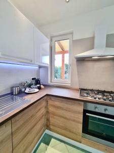 uma cozinha com um lavatório, um fogão e uma janela em Villa Olea in Procida em Procida