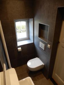 baño pequeño con aseo y ventana en Recreatieappartement BoerdeRijlst - De Winkel en Sint Nicolaasga