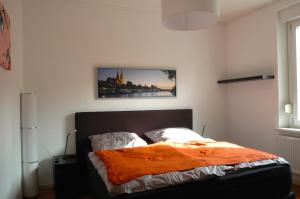 - une chambre avec un lit et une couverture orange dans l'établissement Ferienwohnung Ratisbona, à Ratisbonne