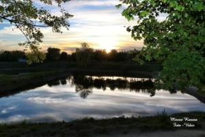 un reflet du coucher de soleil dans un étang dans l'établissement Hanul Marioarei, à Roman