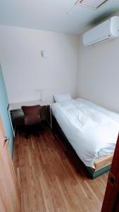 niewielka sypialnia z łóżkiem i biurkiem w obiekcie 宿 inn TEK-TEK w mieście Sanuki