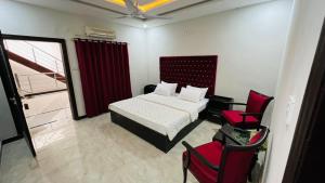 a bedroom with a bed and a red chair at Hotel 11 in Islamabad