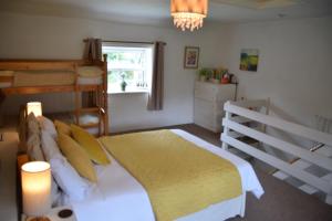 a bedroom with a bed and a bunk bed at Sweetbriar Cottage Bed & Breakfast and Camping in Starbotton