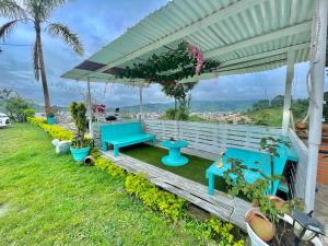 a group of blue benches sitting under a pergola at Mirador San Jose in Santa Rosa de Cabal