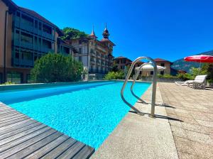 a swimming pool with an umbrella next to a building at "Boho Oase" with lake view and pool in Därligen